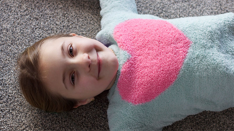 smiling girl laying on clean carpet